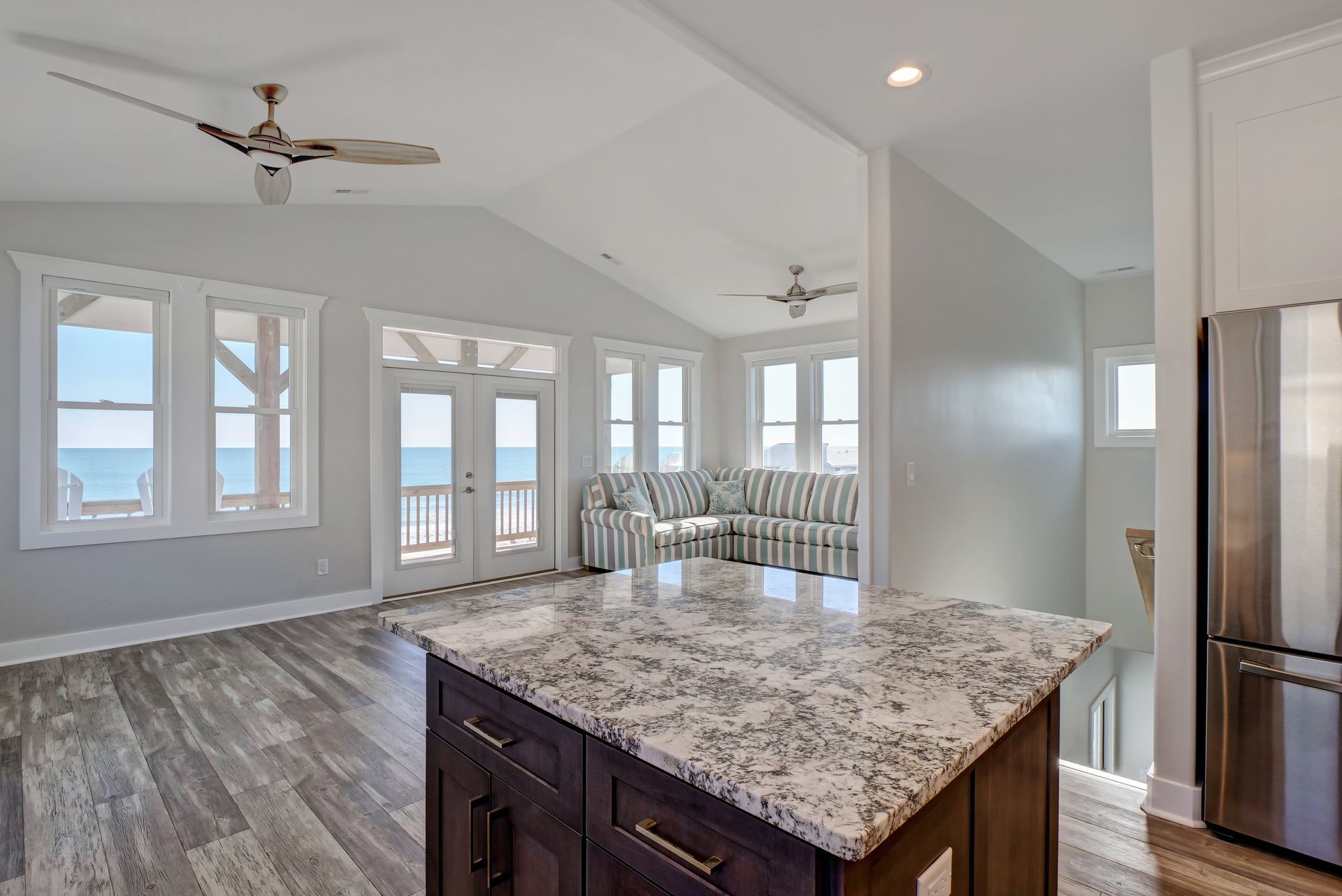 A kitchen with granite counter tops and a stainless steel refrigerator.