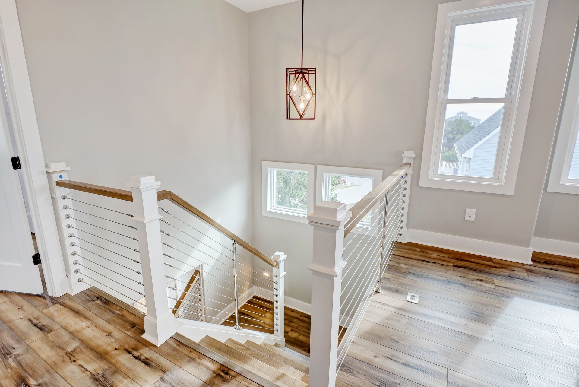 A staircase in a house with wooden floors and a white railing.