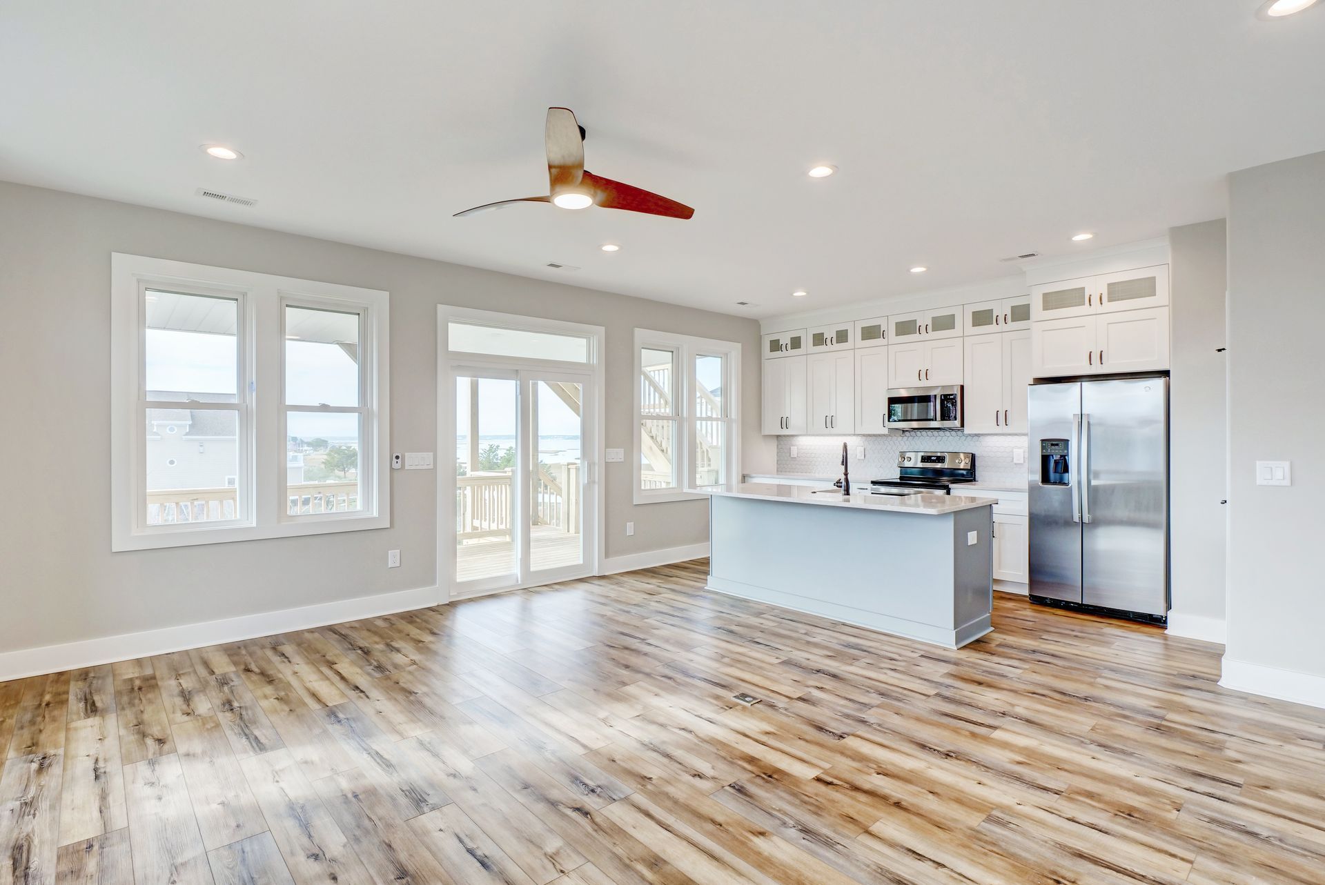 There is a ceiling fan in the living room and a kitchen.