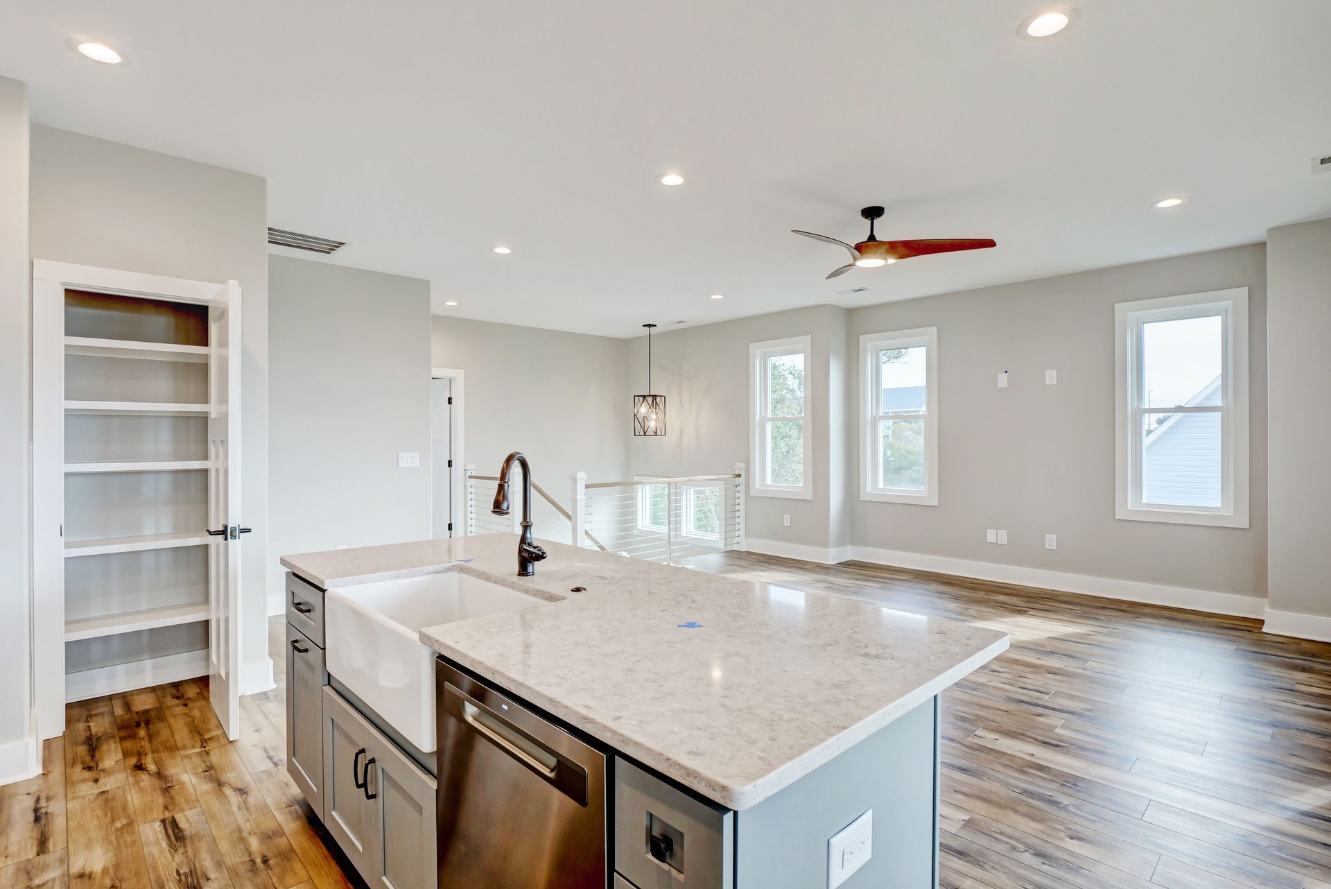 A kitchen with a sink , dishwasher , and ceiling fan.