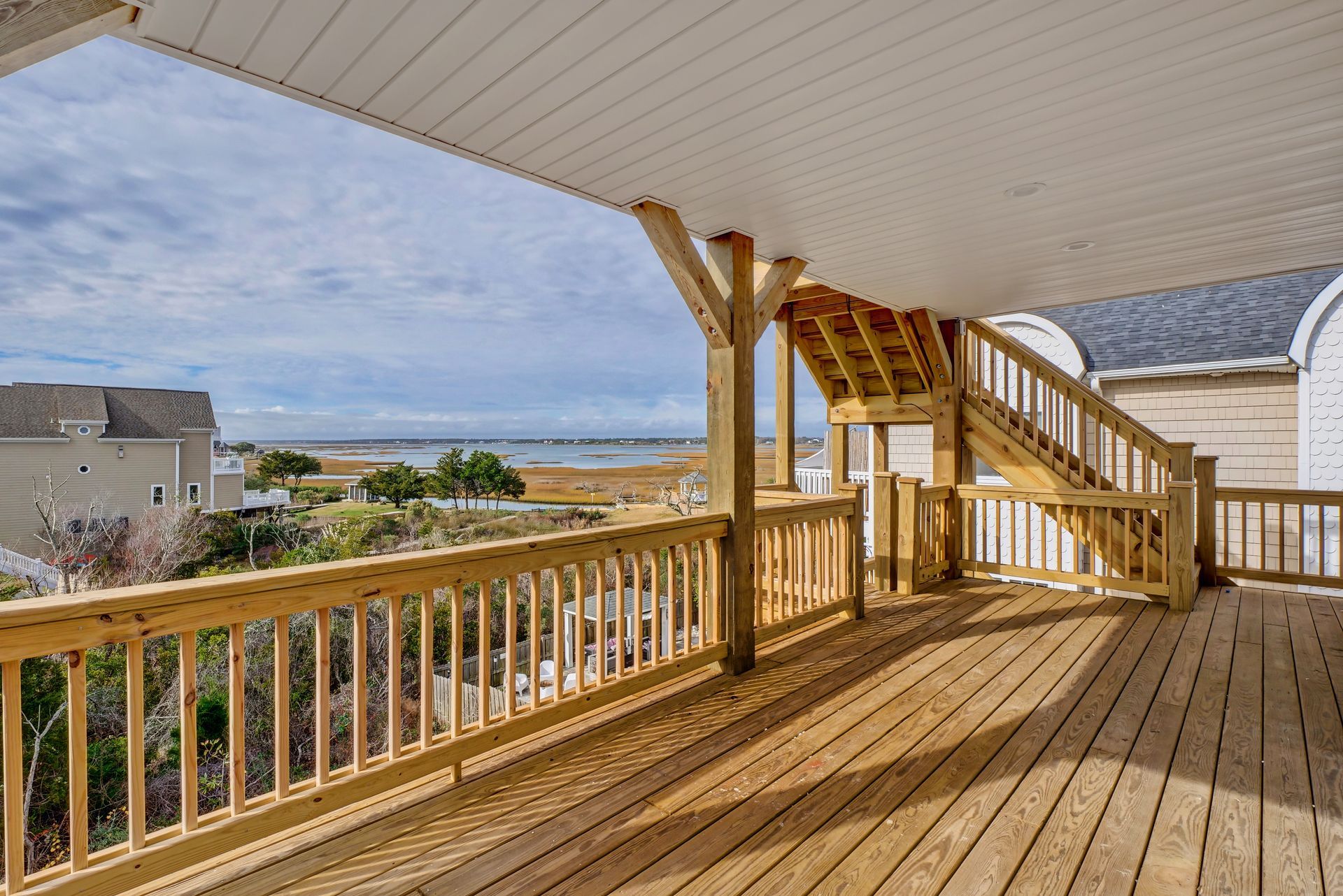 A large wooden deck with a view of the ocean.