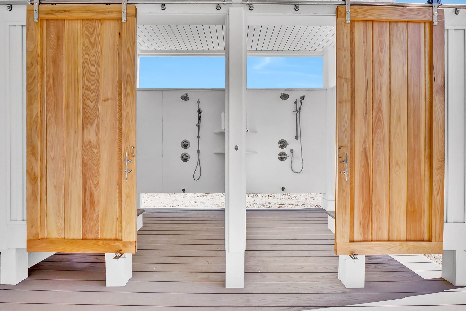 A row of outdoor showers with wooden doors