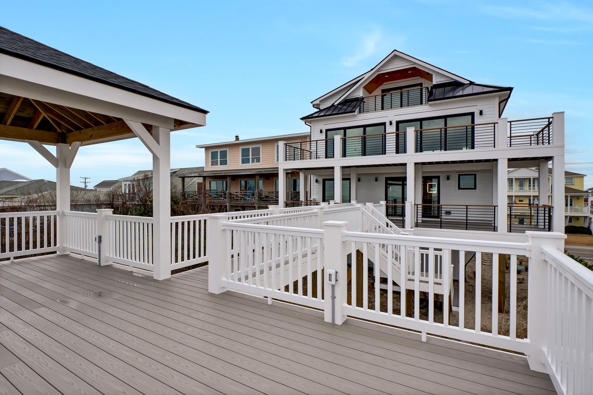 A large house with a large deck and a white railing
