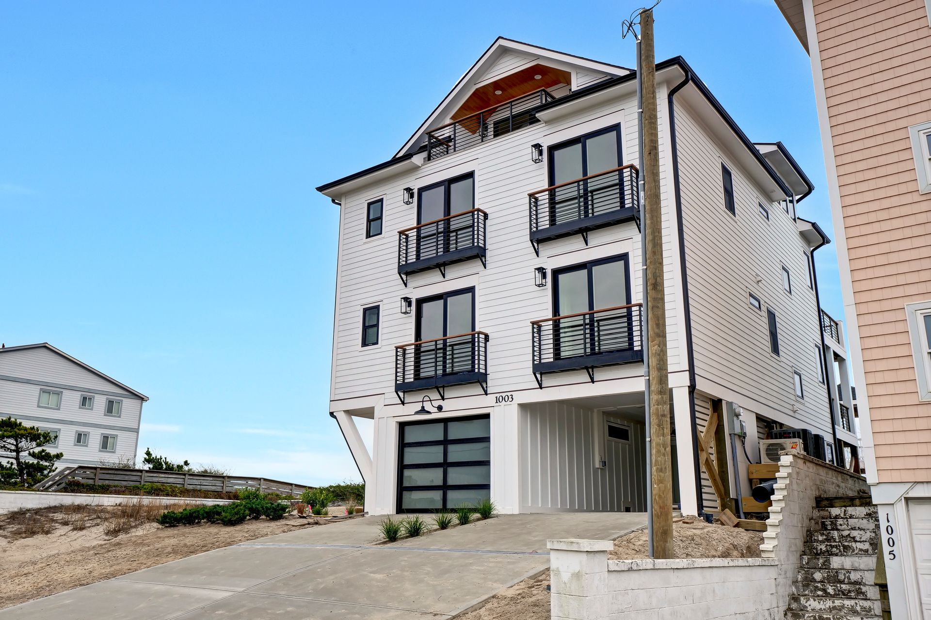 A large white house with a lot of windows and balconies is sitting on top of a hill.
