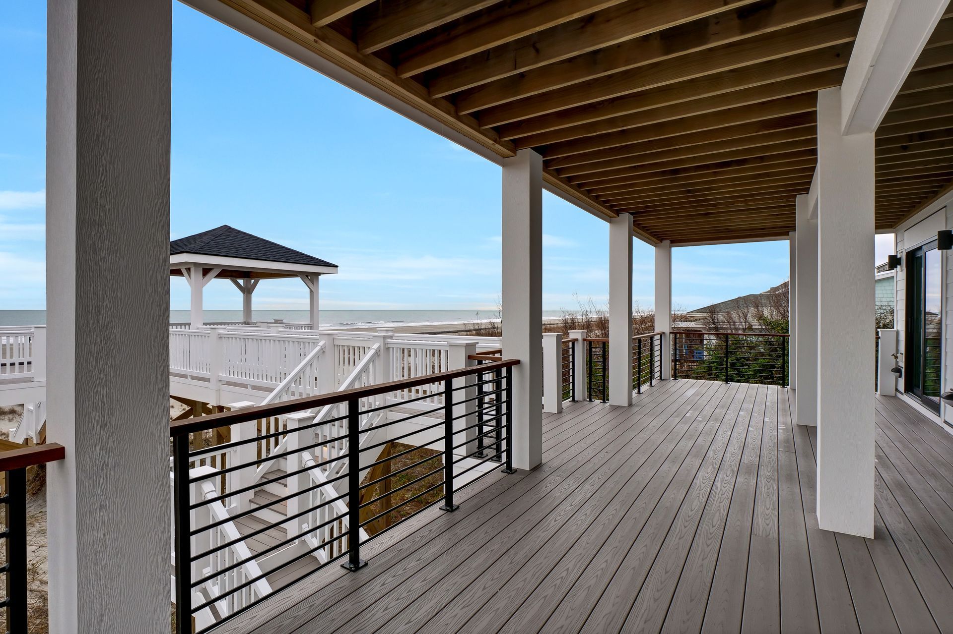 There is a large deck with a view of the ocean.