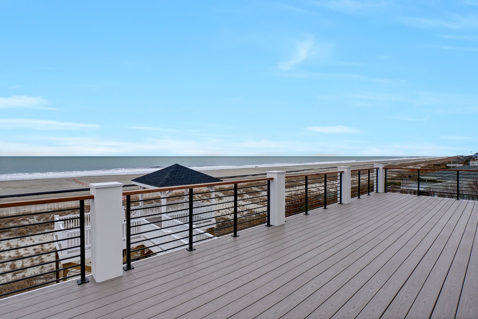 There is a large deck with a view of the ocean.