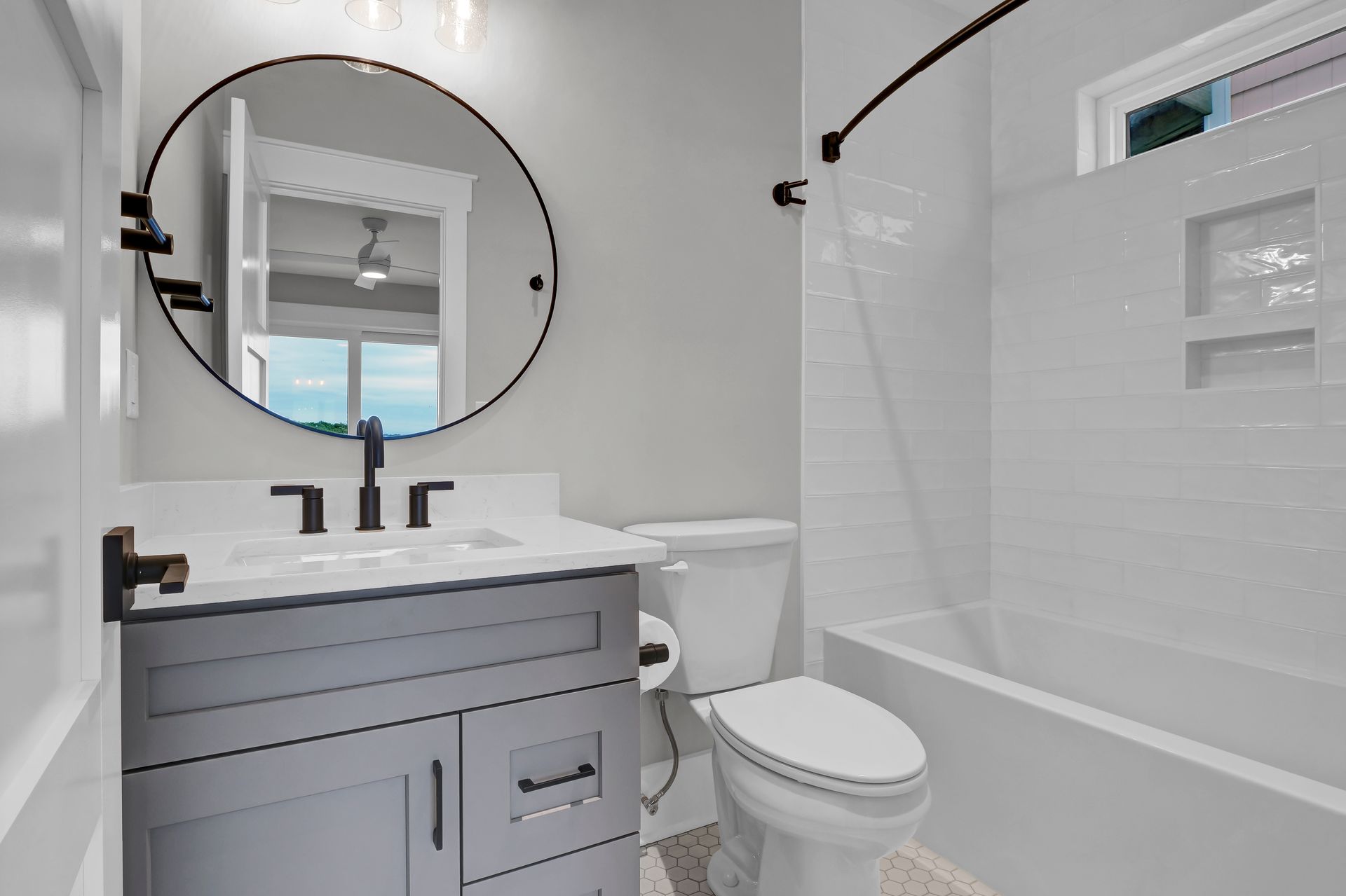 A bathroom with a toilet , sink , mirror and bathtub.