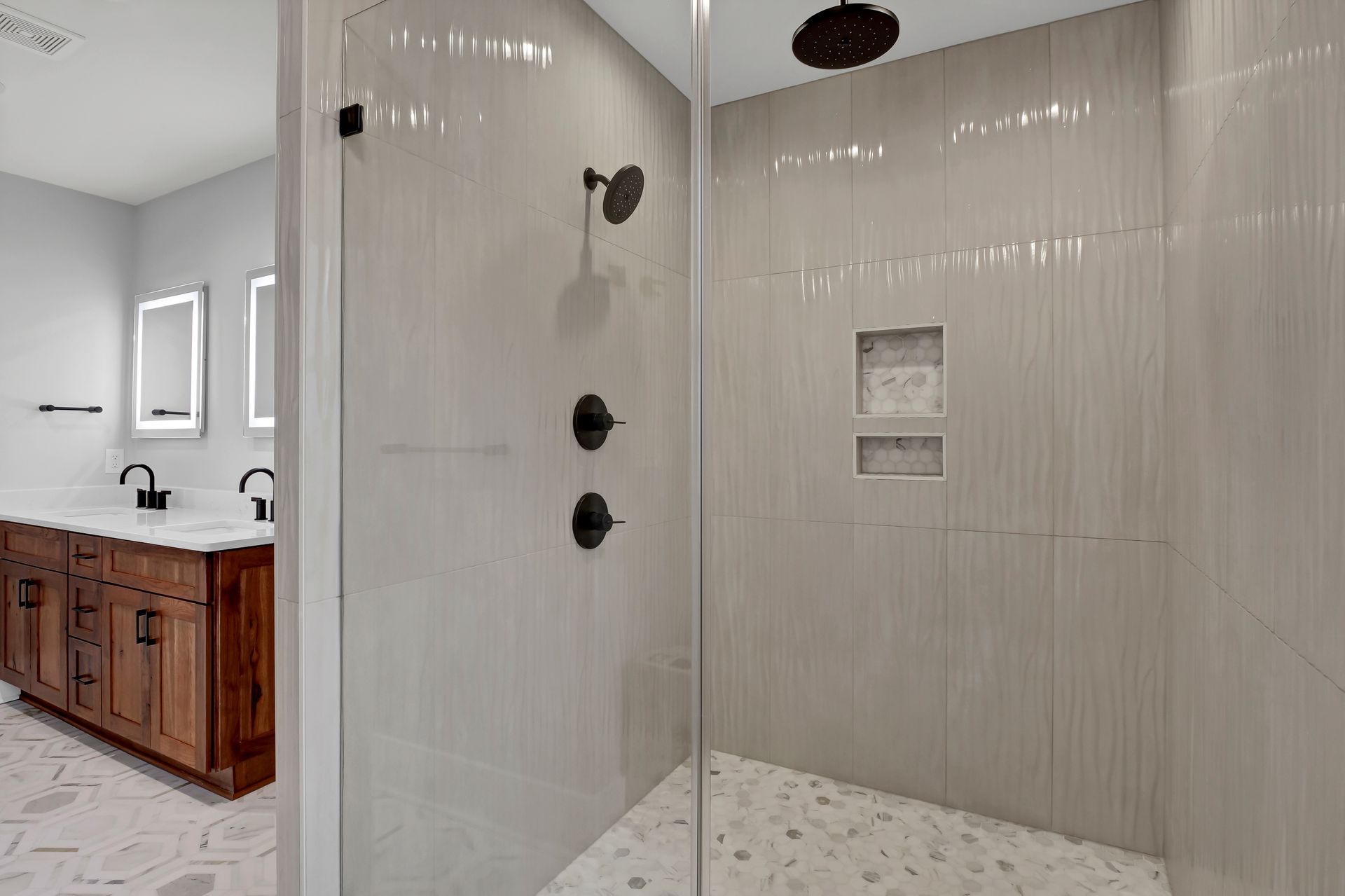 A bathroom with a walk in shower and a sink.