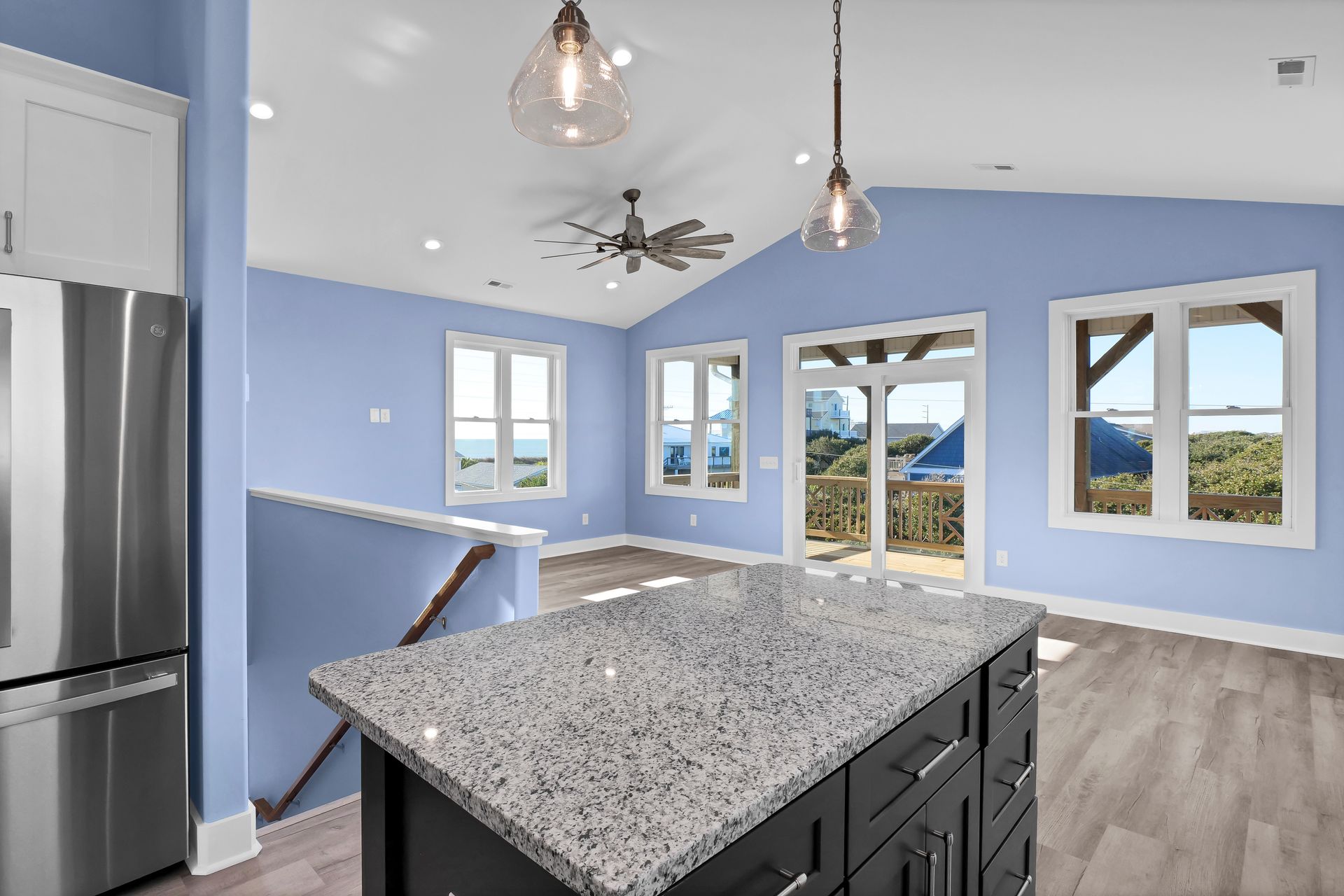 A kitchen with blue walls and a granite counter top.