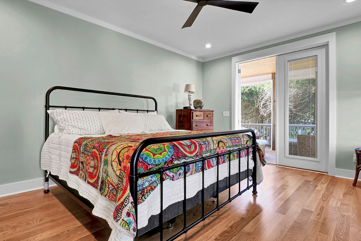 A bedroom with a bed and a ceiling fan