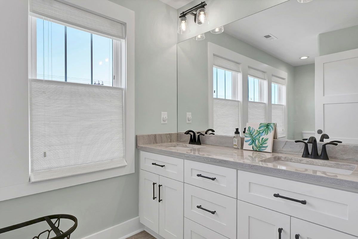 A bathroom with two sinks and a large mirror