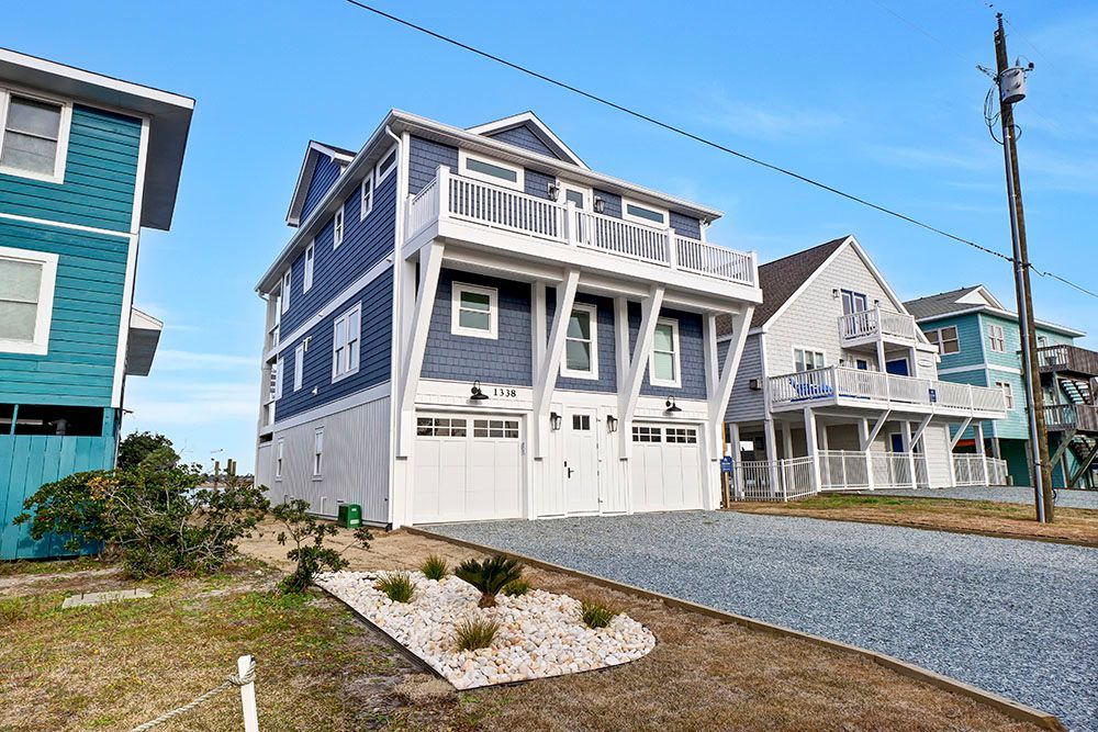 A large blue and white house with a garage and a driveway