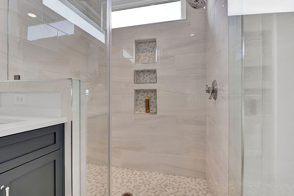 A bathroom with a walk-in shower and a sink