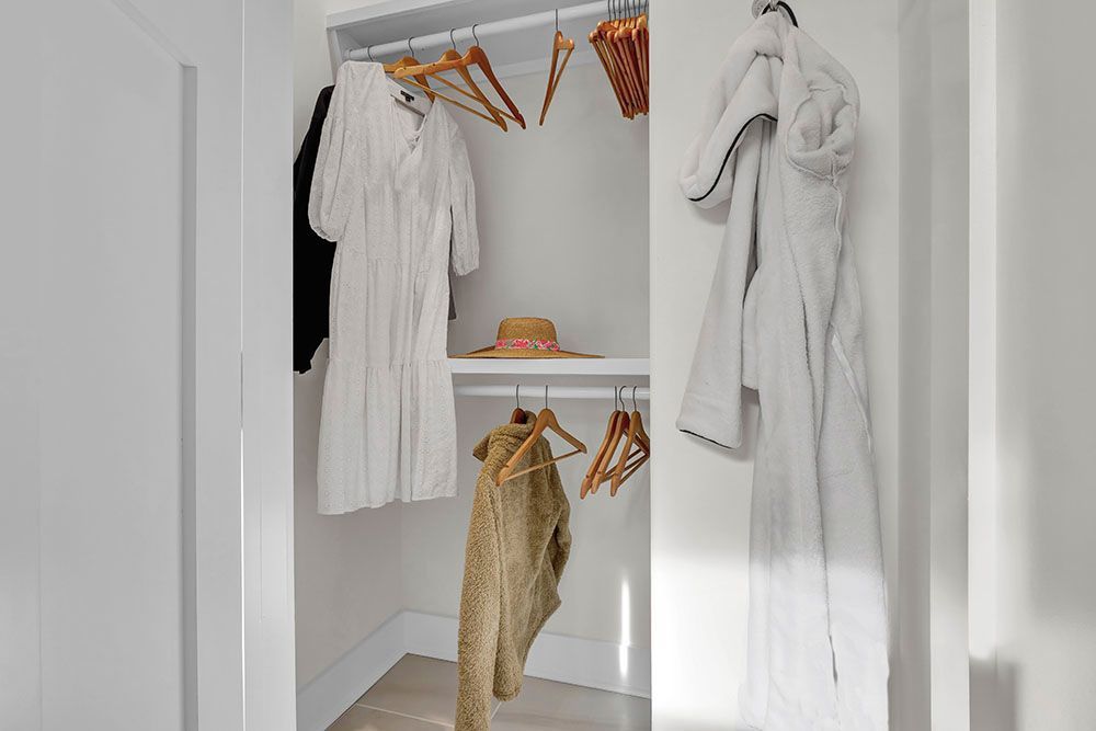 A walk-in closet filled with clothes and a hat