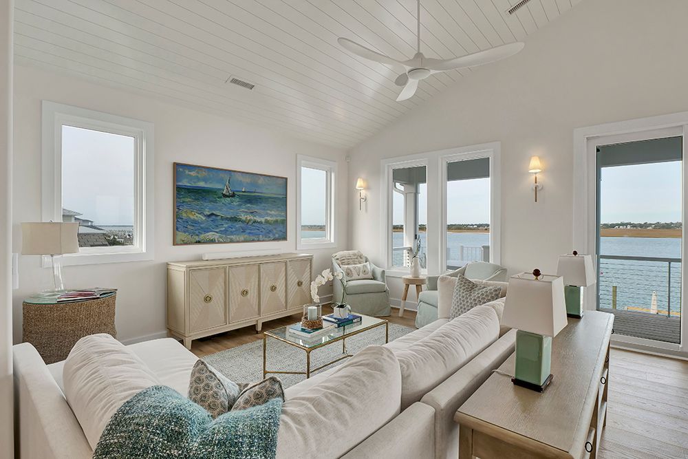 A living room with a couch, chairs, a table, and a ceiling fan