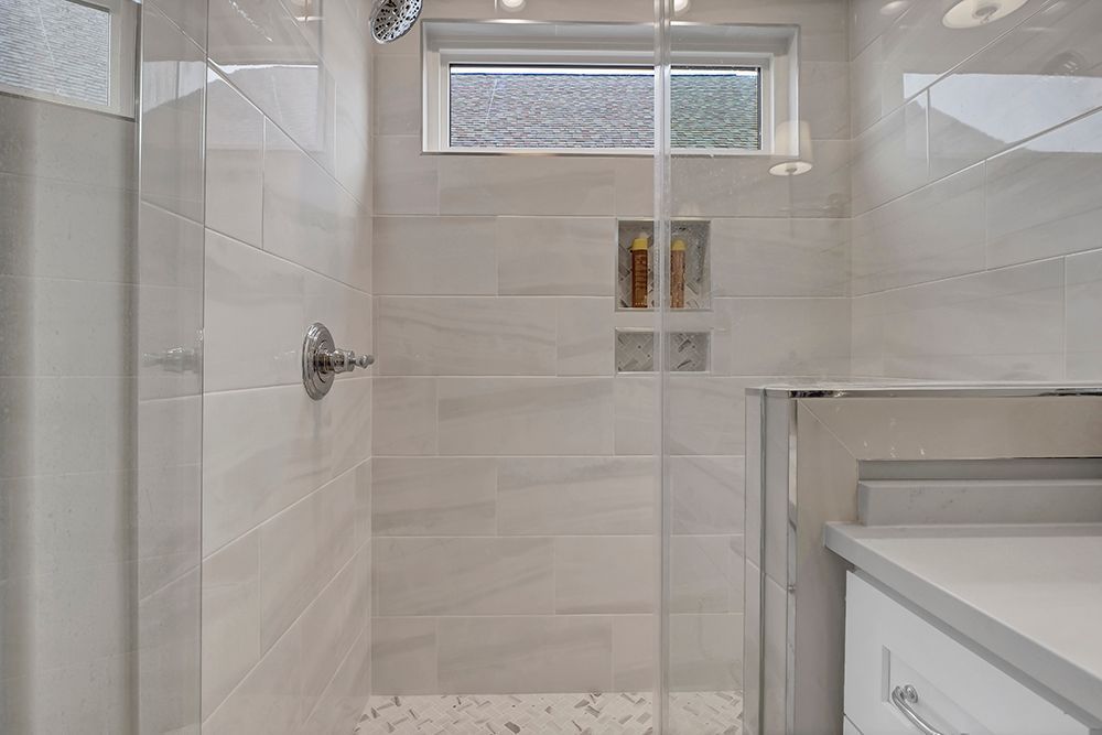 A bathroom with a walk-in shower and a window