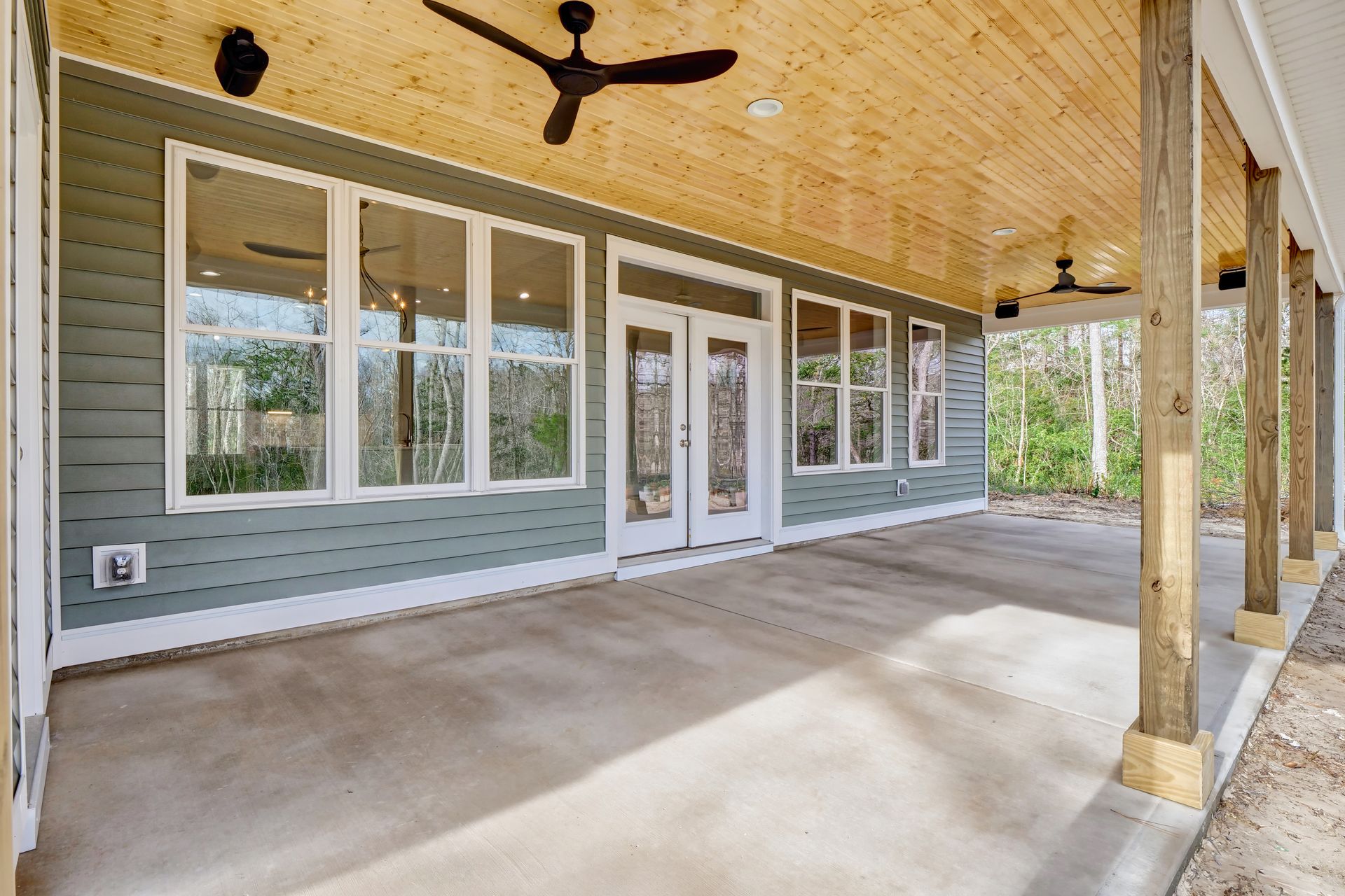 A large porch with a ceiling fan and a lot of windows