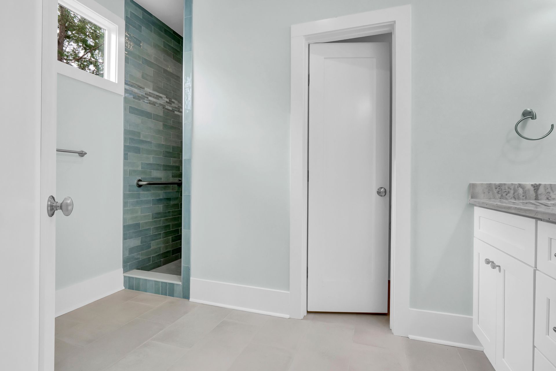 A bathroom with a walk in shower and a sink.