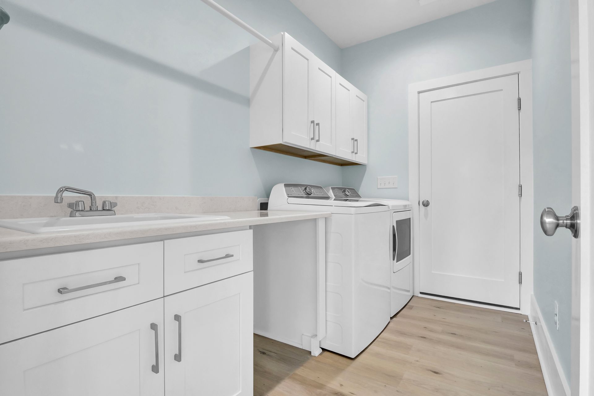 A laundry room with a washer and dryer and a sink.