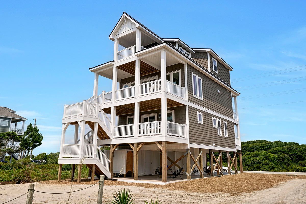 A large house with a lot of windows and balconies is on the beach