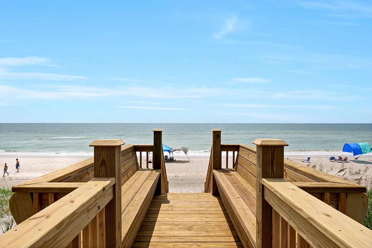 A wooden walkway leading to the beach and ocean