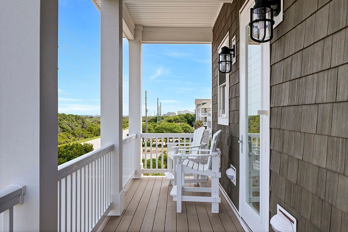 A porch with chairs and a view of the ocean