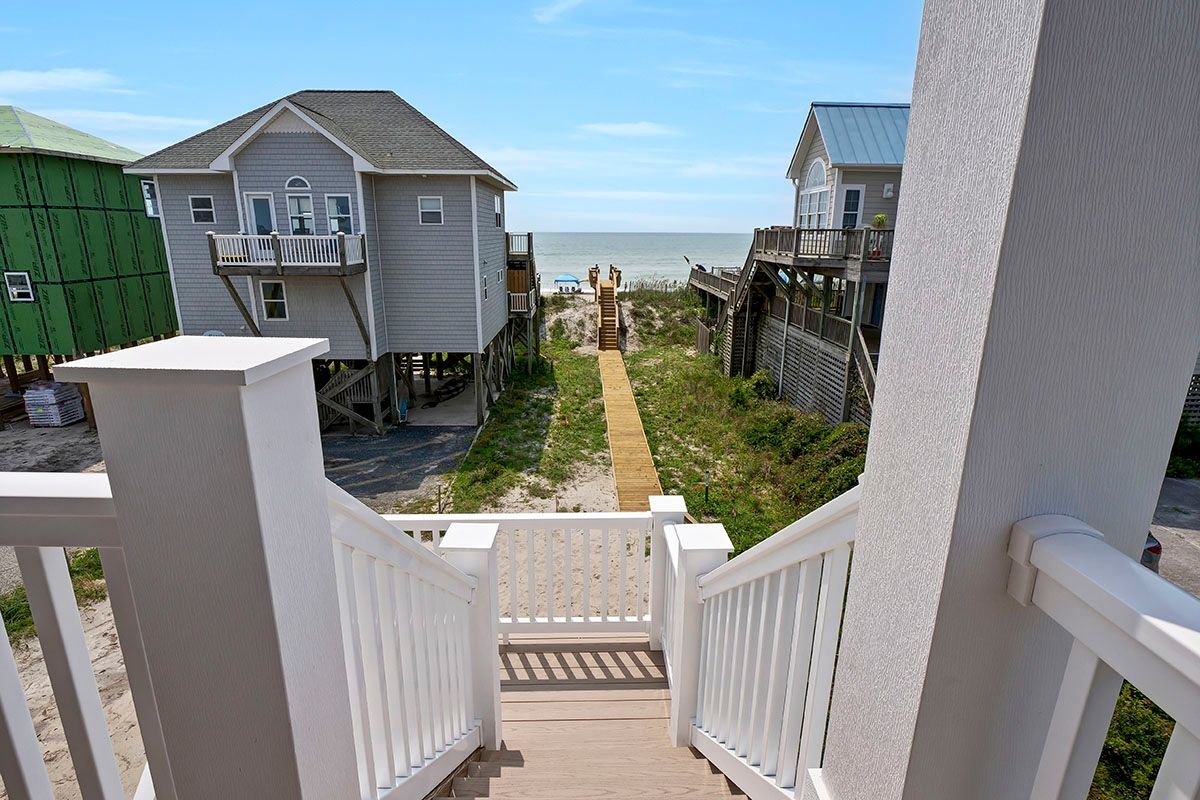 A view of a house from a balcony with stairs leading up to it