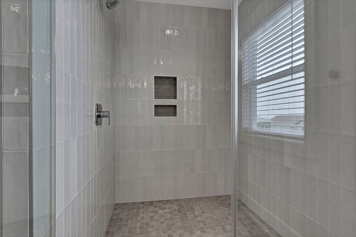 A bathroom with a walk-in shower and a window