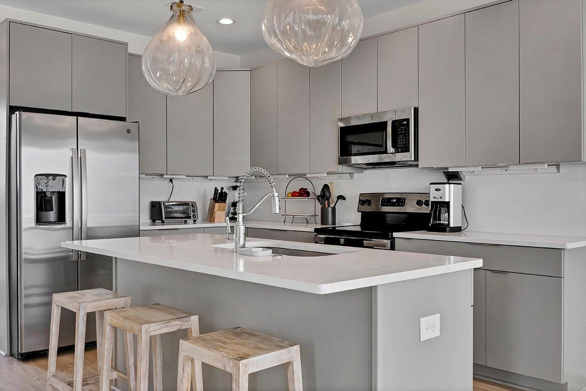 A kitchen with stainless steel appliances and gray cabinets