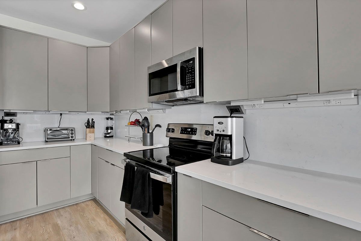 A kitchen with a stove, microwave, and coffee maker