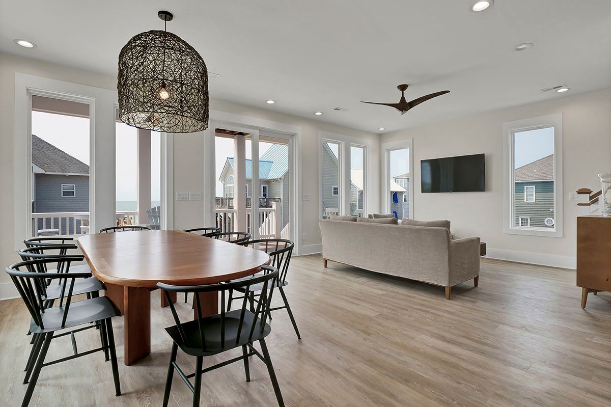 A living room with a table and chairs and a ceiling fan