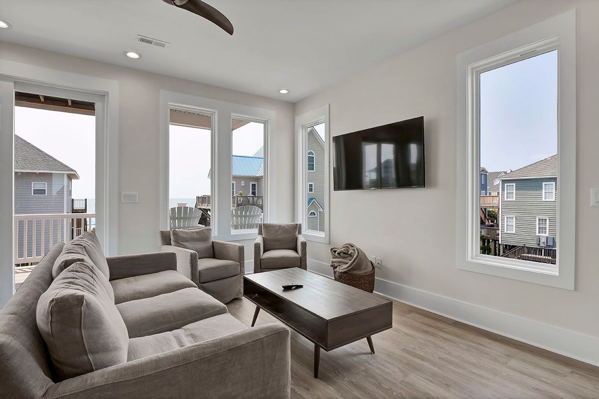 A living room with a couch, chairs, coffee table, and television