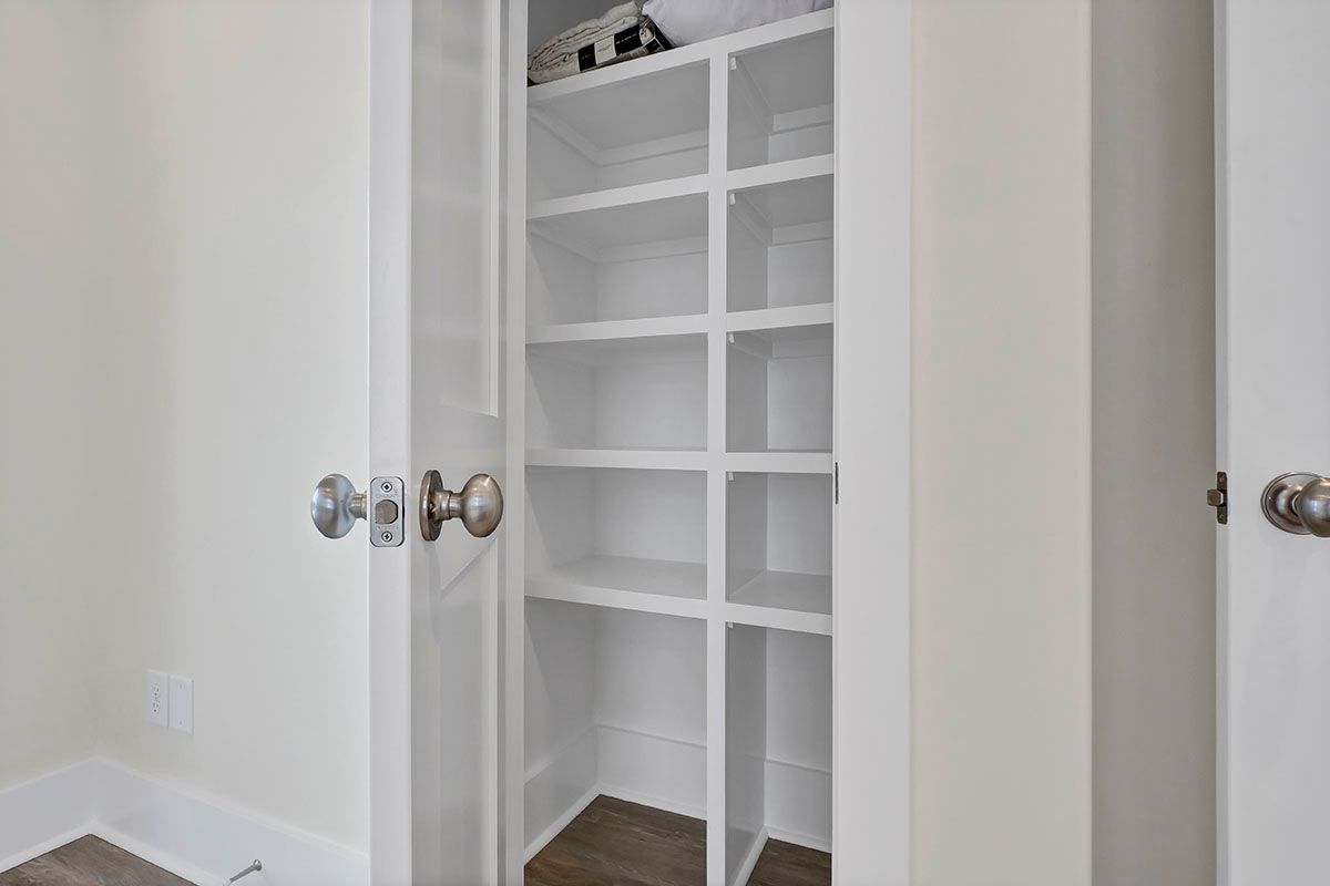 A closet with shelves and a door in a room