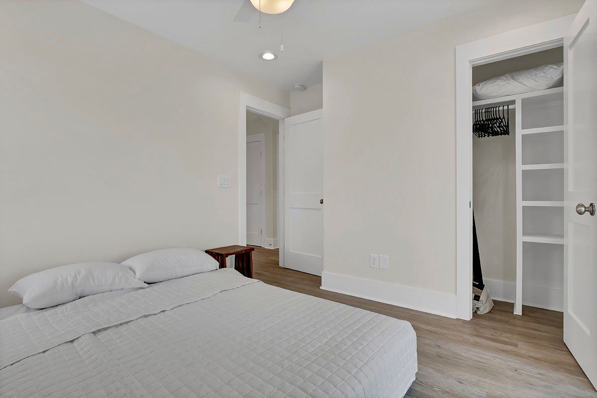 A bedroom with a bed, closet, and a ceiling fan