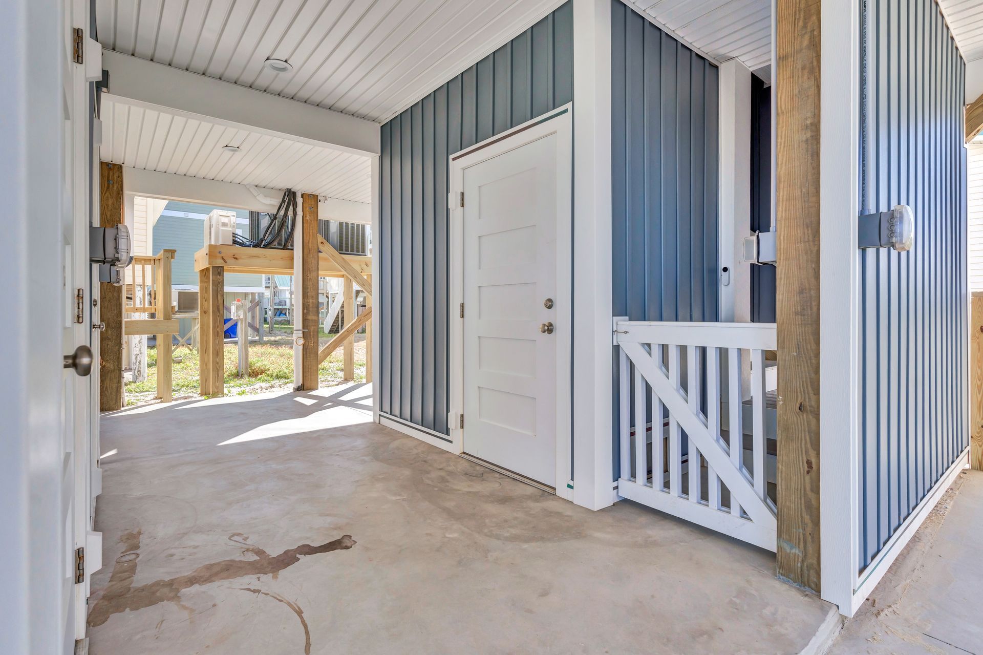 A blue and white house with a white door and a white gate.