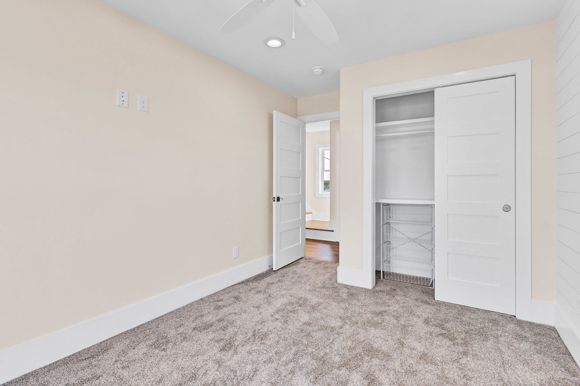 An empty bedroom with a closet and a ceiling fan.