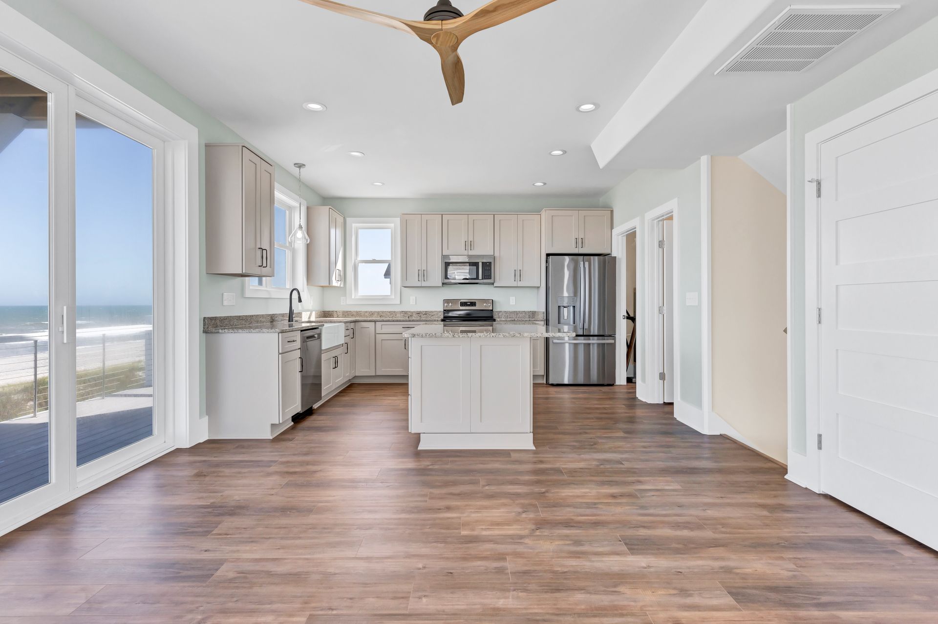 A kitchen with stainless steel appliances and a ceiling fan.