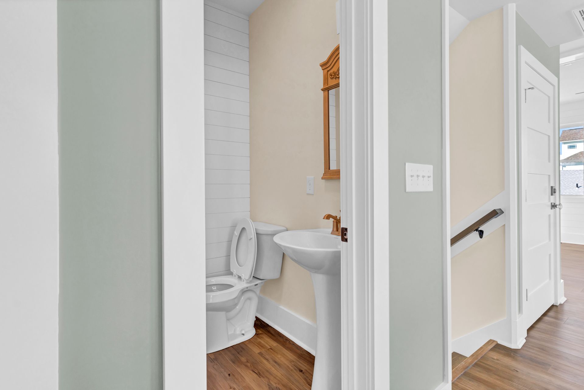 A bathroom with a toilet , sink and mirror.