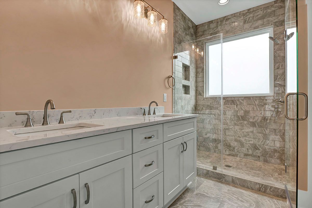 A bathroom with two sinks and a walk-in shower