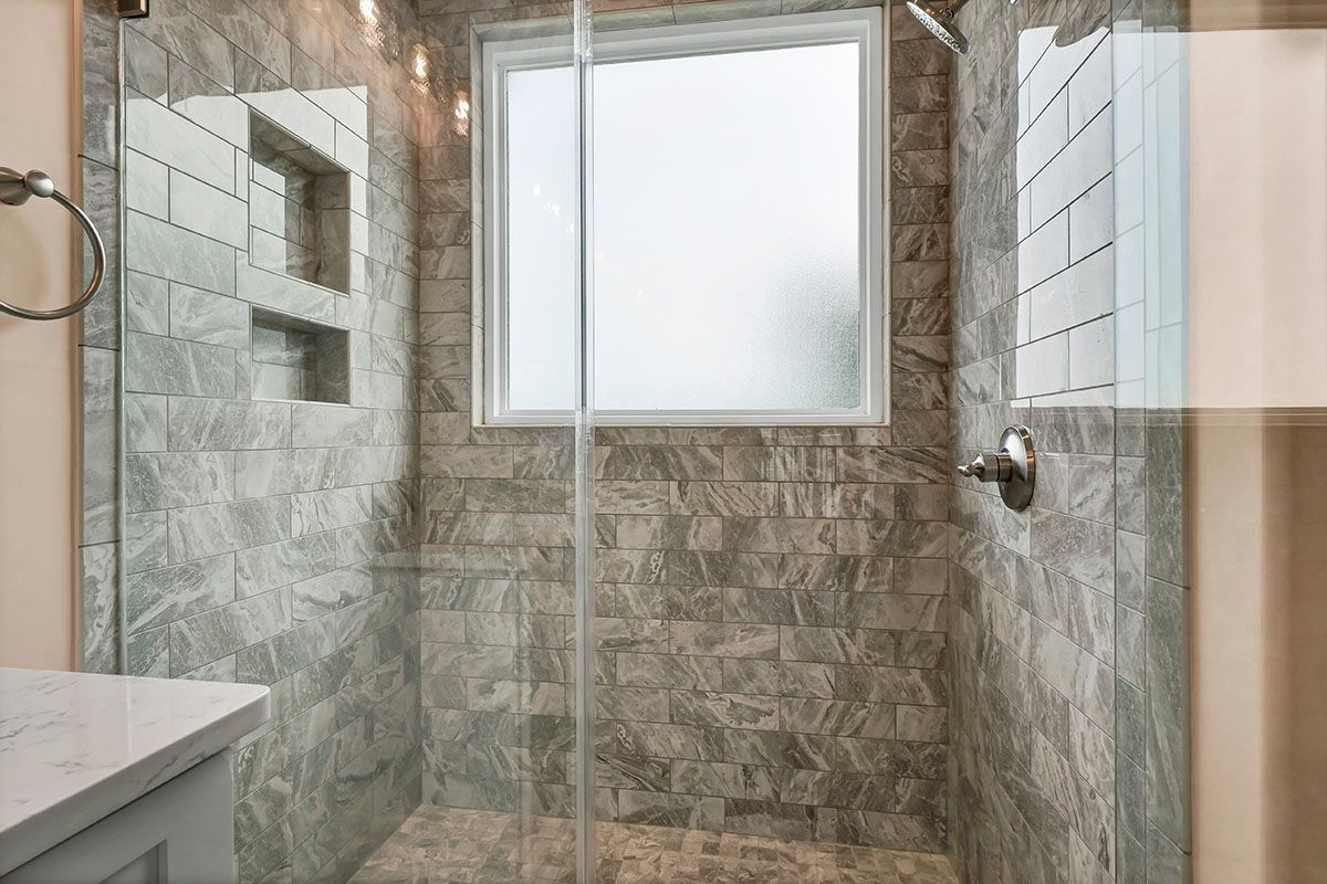 A bathroom with a walk-in shower and a window