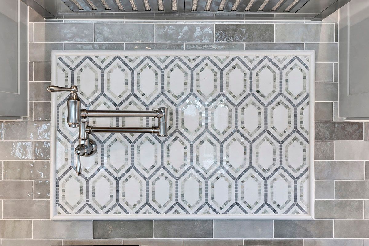 A kitchen with a stove-top oven and a faucet on the wall