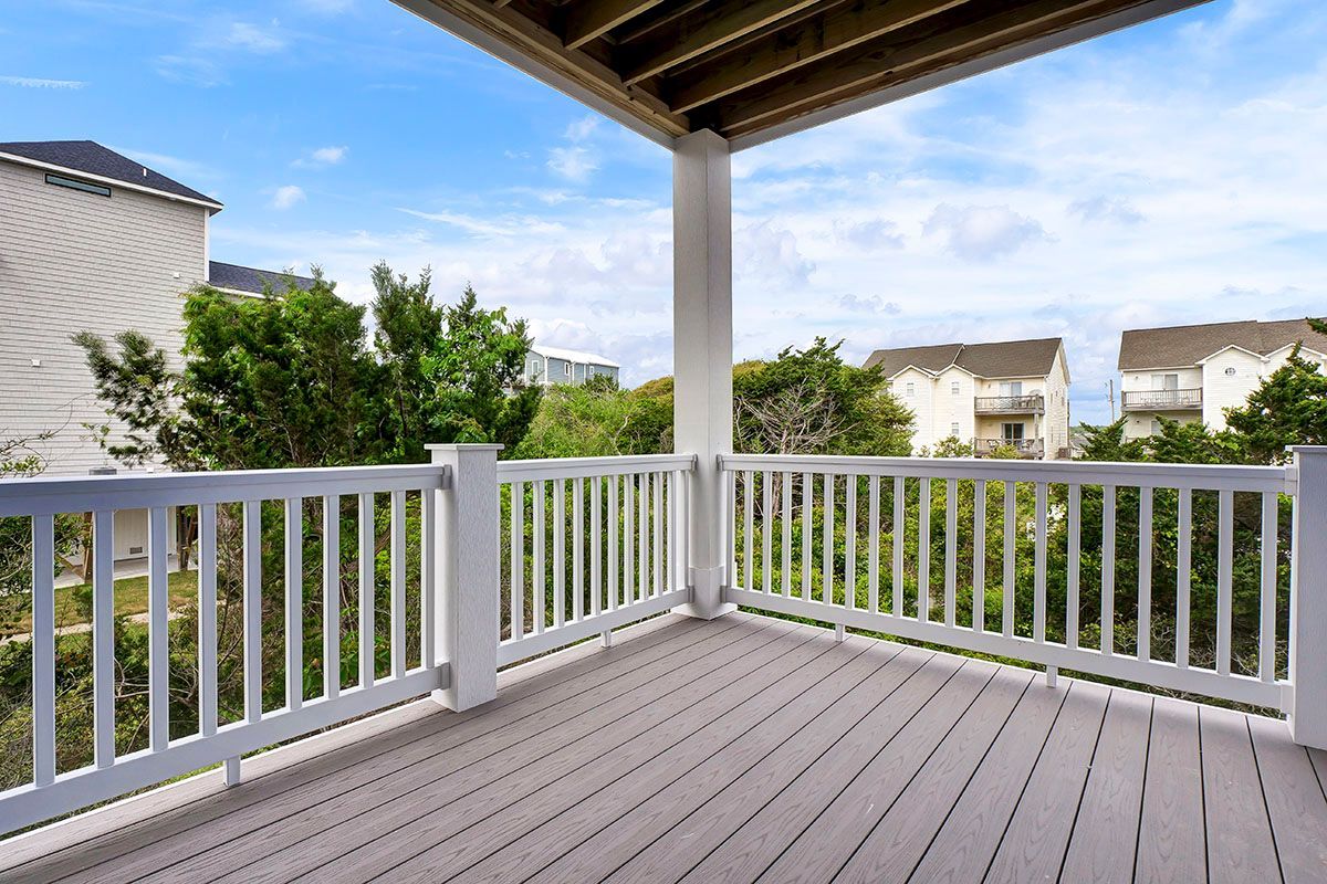 An empty deck with a white railing