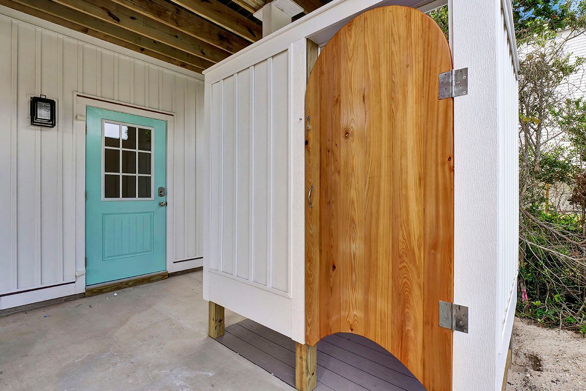 An outdoor shower with a wooden door