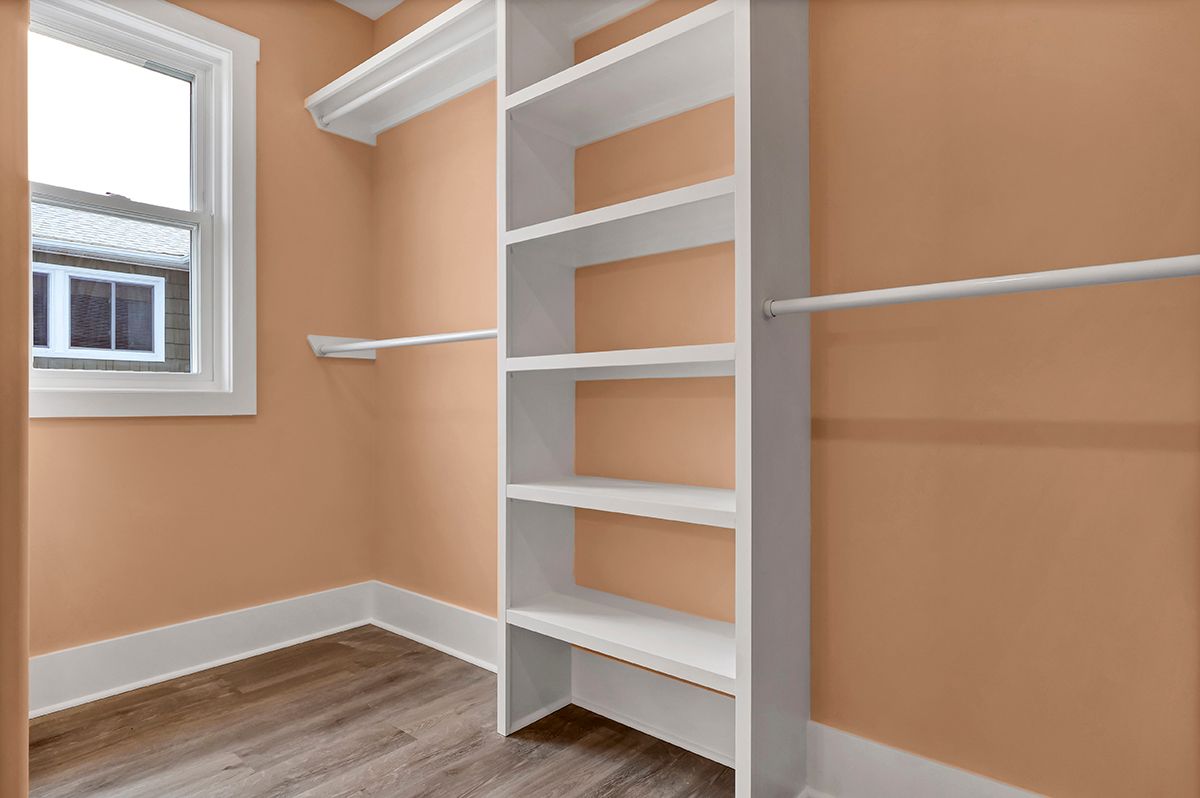An empty walk-in closet with a window and shelves