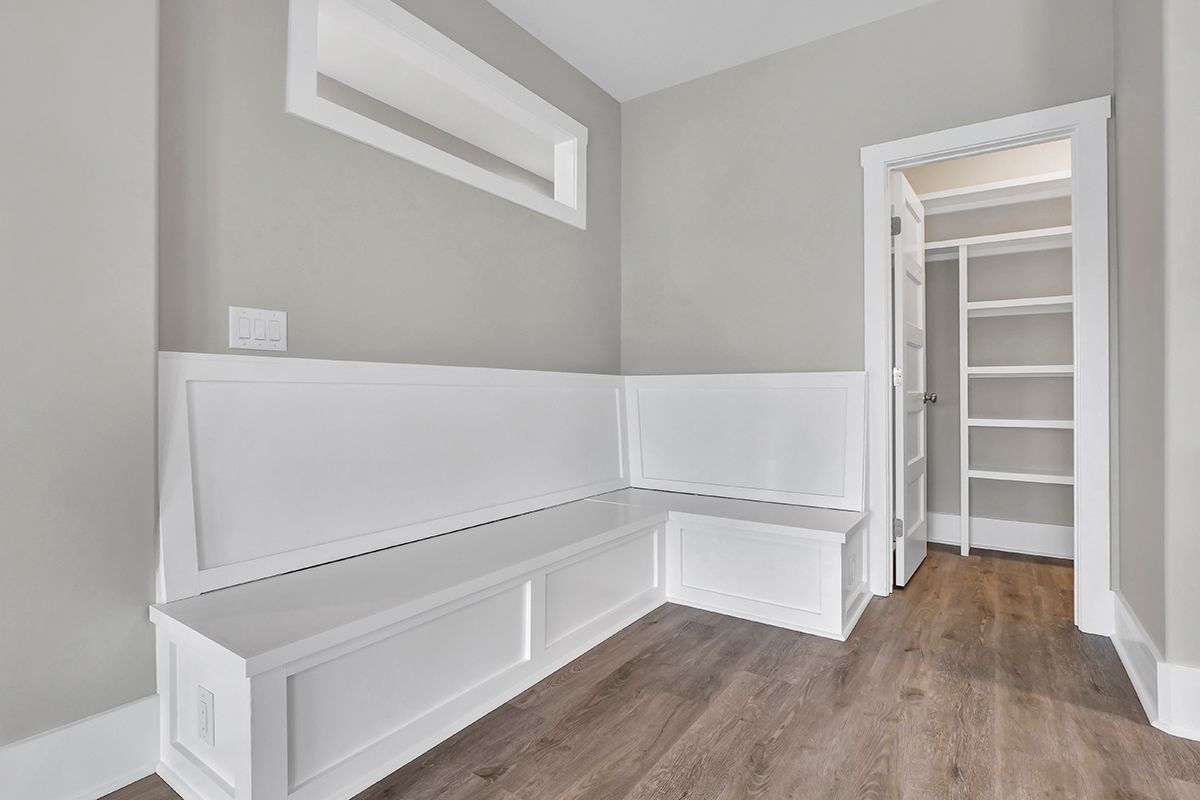 A room with a bench and a walk-in closet