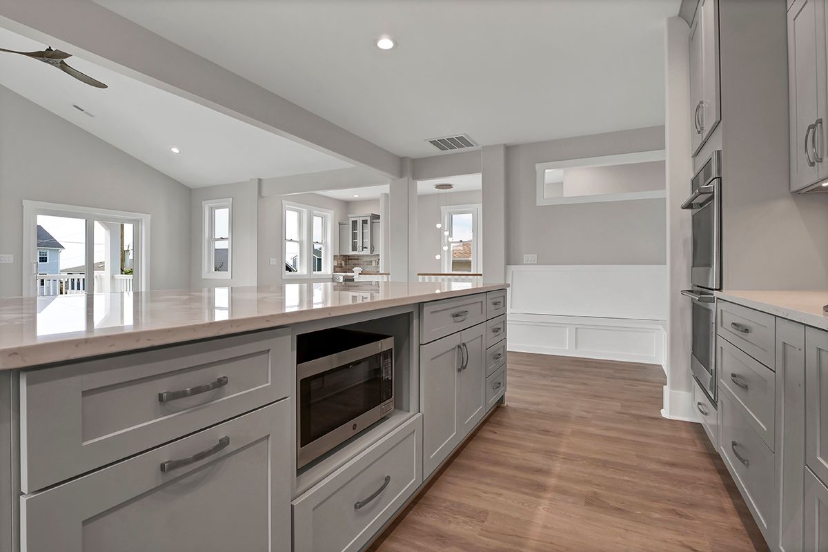 A kitchen with white cabinets and a microwave oven