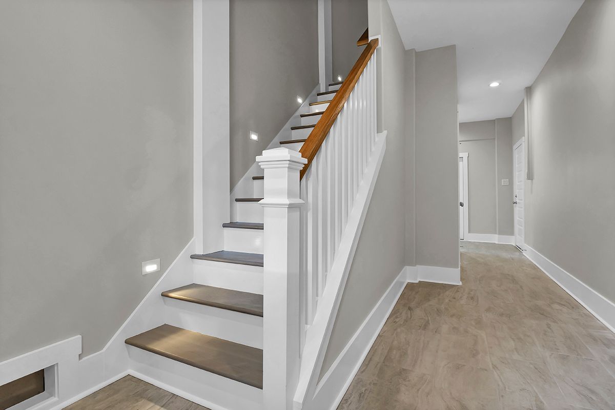 A hallway with stairs leading up to the next floor of a house
