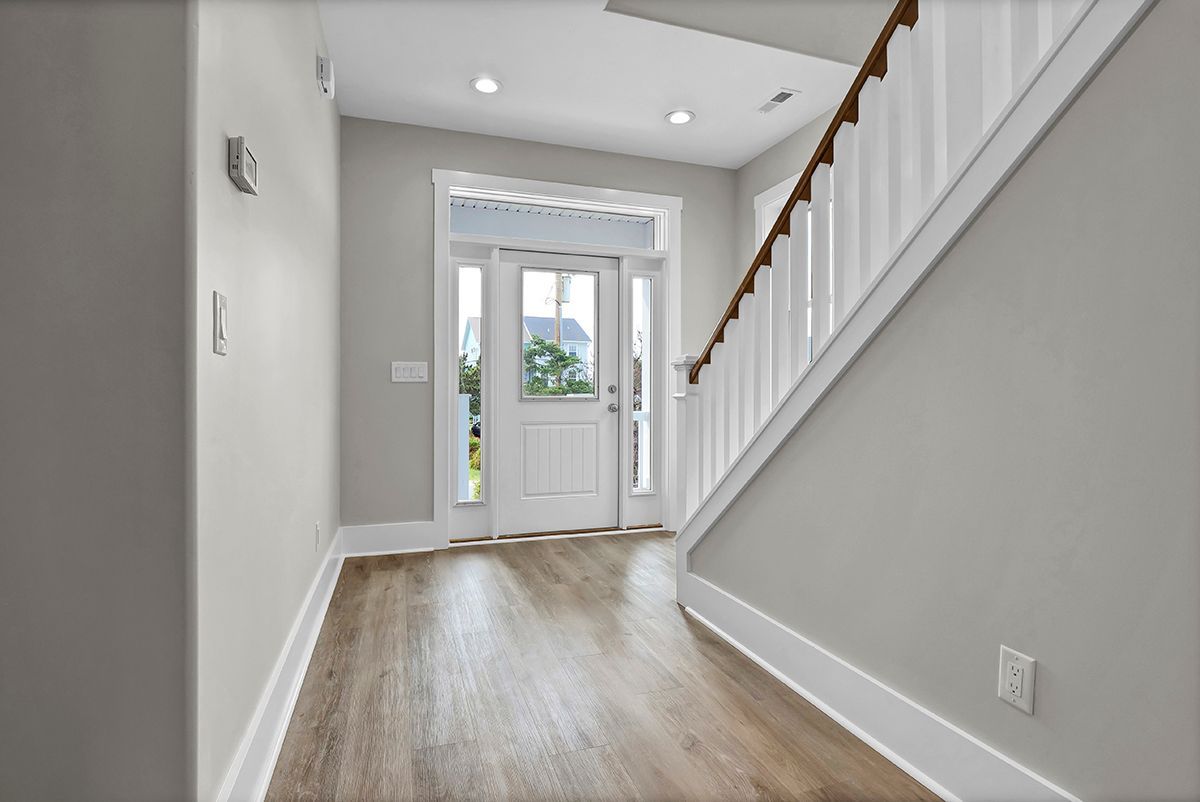 A hallway with a white door and stairs