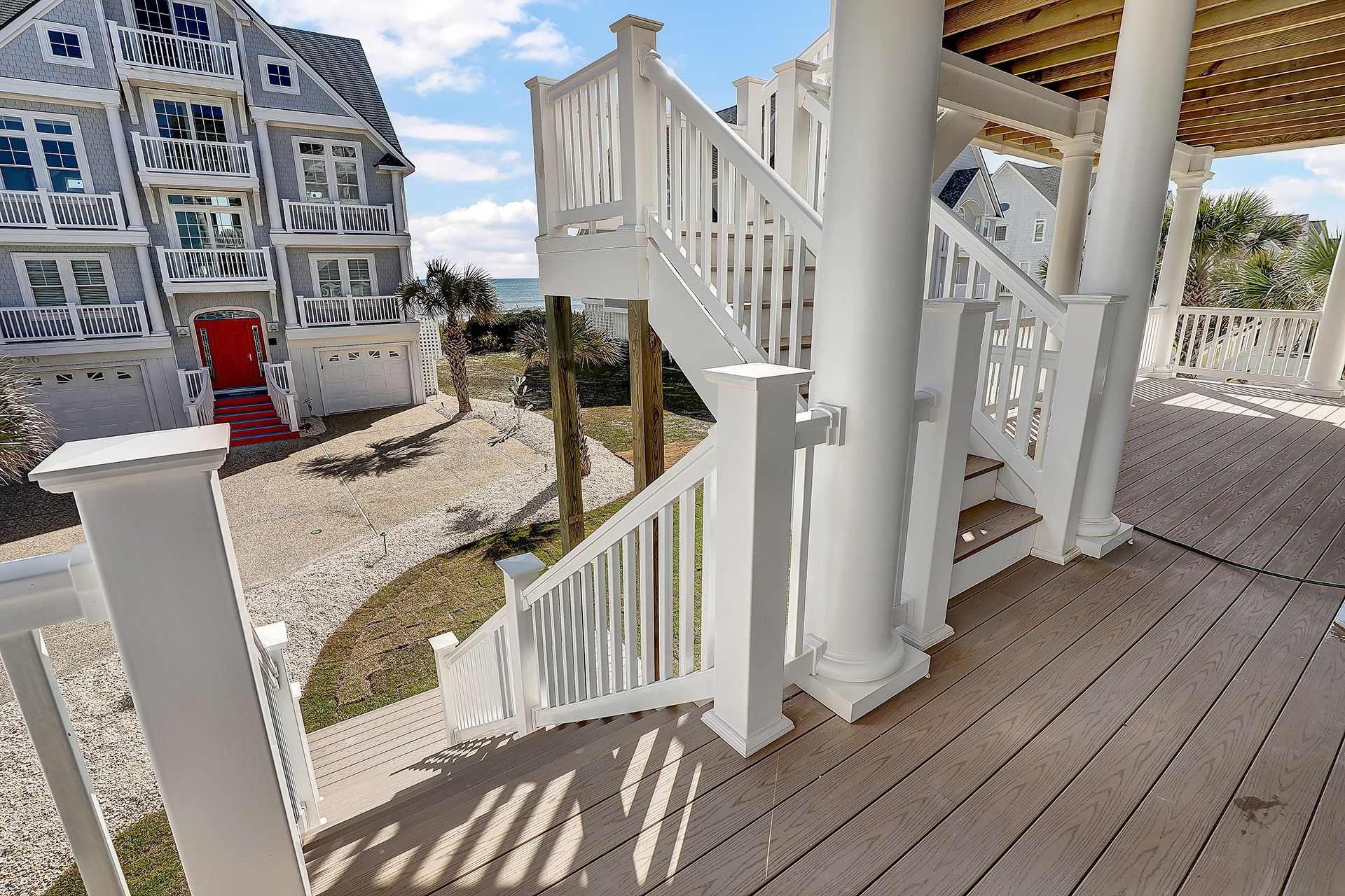 A white deck with stairs leading up to a house