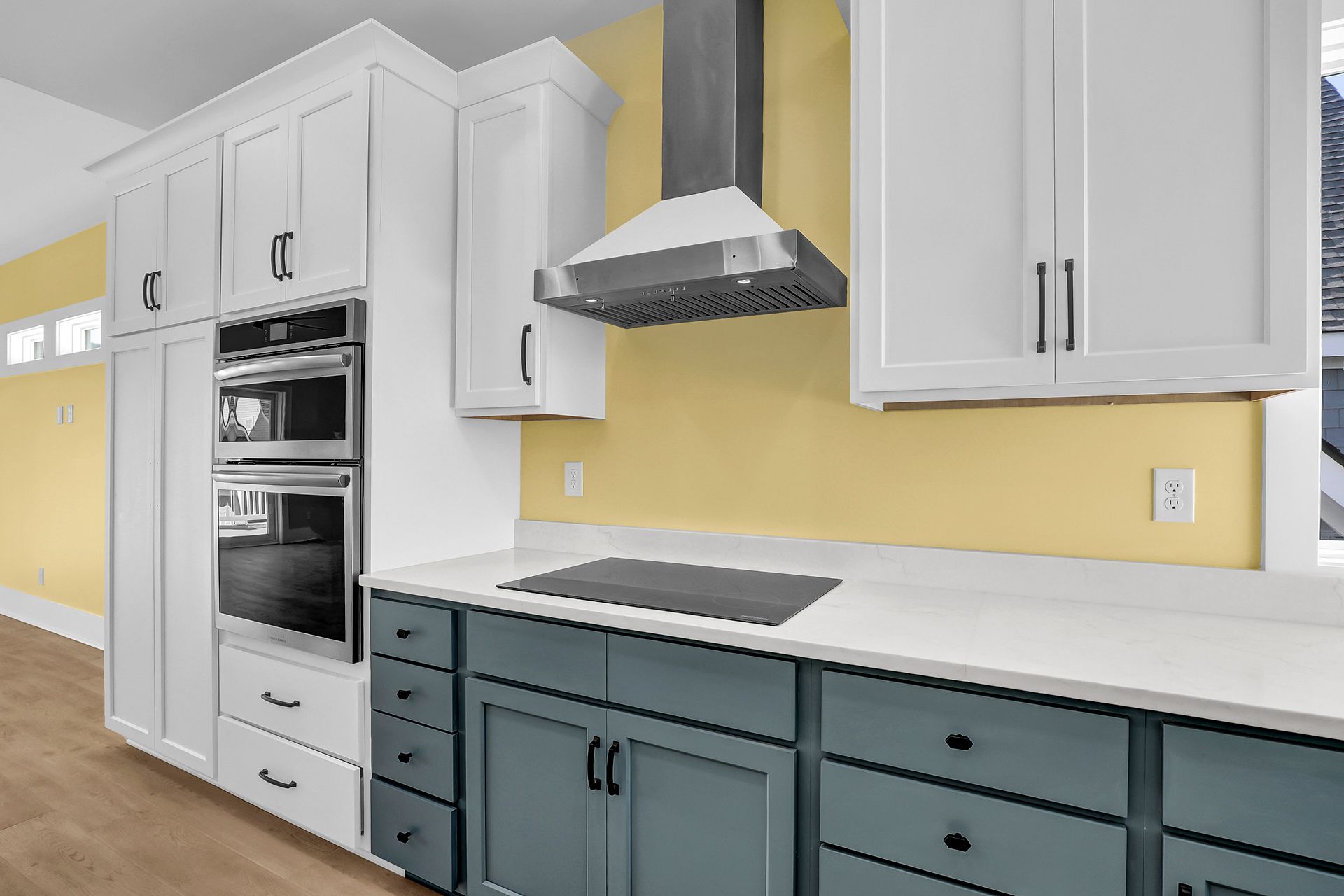 A kitchen with white cabinets, blue drawers, and an electric stove